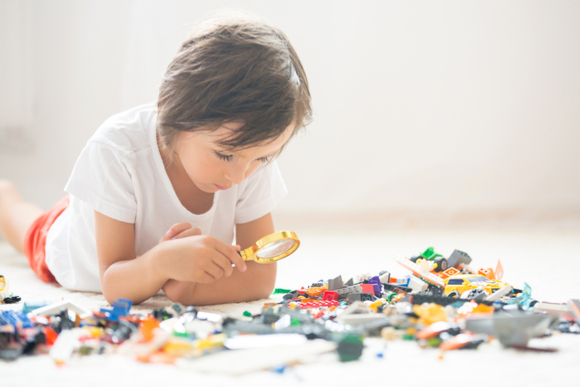5歳の子供が様々な大きさや形のブロックで集中して遊んでいる様子